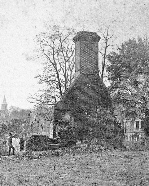 C.1900 image showing the remains of the one of the advance buildings for the Governors Palace. These two flanking structures were all that remained of the 18th century complex. They were reportedly disassembled by Union fatigue details and the bricks were utilized for the improvement of Fort Magruder. Photo in the collections of Colonial Williamsburg.