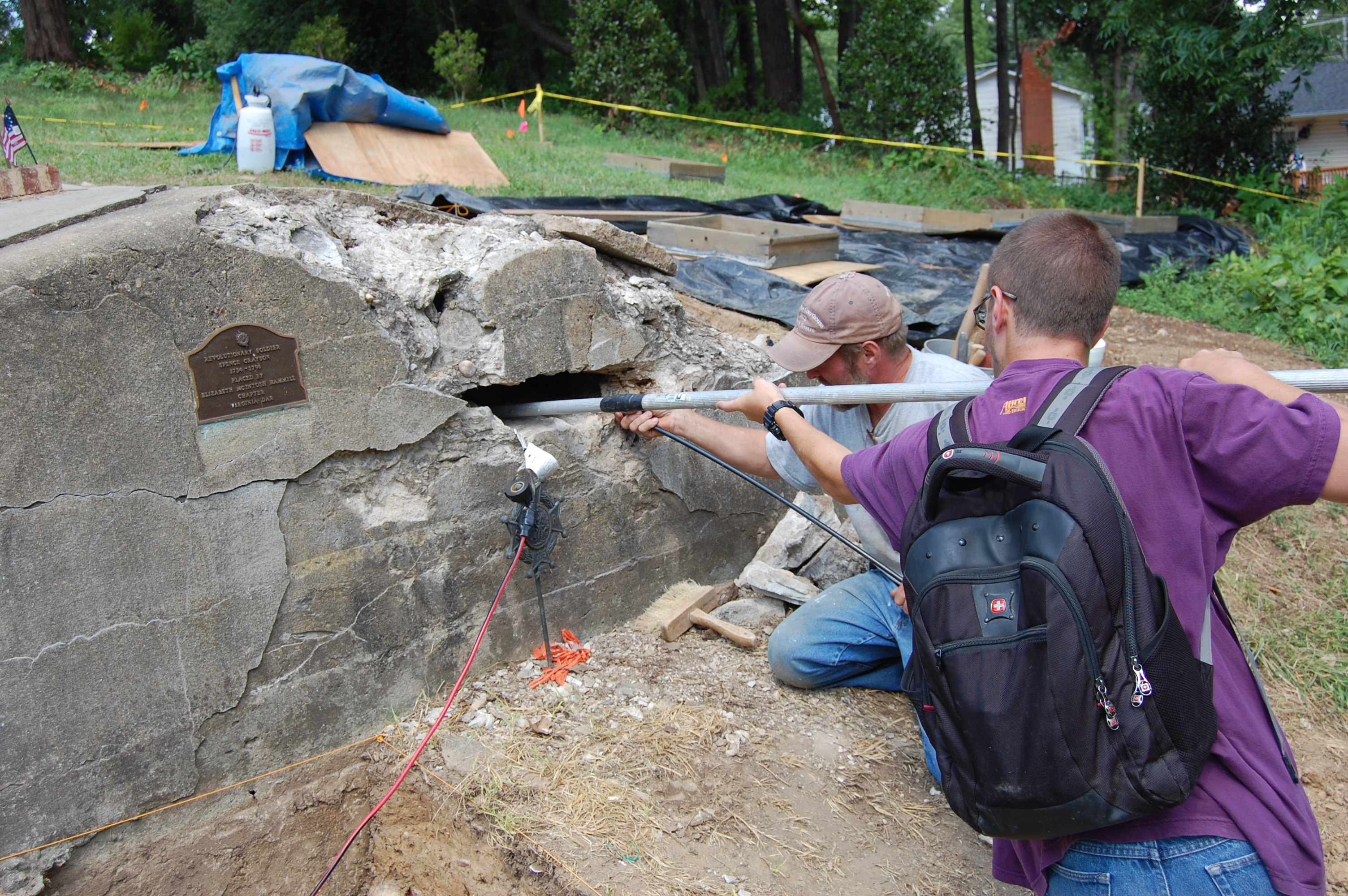 WOODBRIDGE, VA - AUGUST 13: Fritz and Ryan Korzendorfer record video of the interior of the Grayson Tomb in Woodbridge August 13, 2014. Frits and Ryan work for  County?s Historic Preservation Division.  William Grayson, lawyer, first and only U.S. Senator from Prince William County and delegate to the Constitutional Convention, is buried on property formerly part of "Belle Air" the family plantation. Grayson organized Prince William county's first revolutionary militia unit in 1774. Now his  grave is falling apart, has gone through a lot over the years, possibly blown up in the Civil War, spray-painted by vandals who climbed inside the tomb  and is now being fixed because a private citizen who really cares about graves paid for the supplies and the county agreed to do the work. (Photo by Justin S. Patton/Prince William County Planning Office)