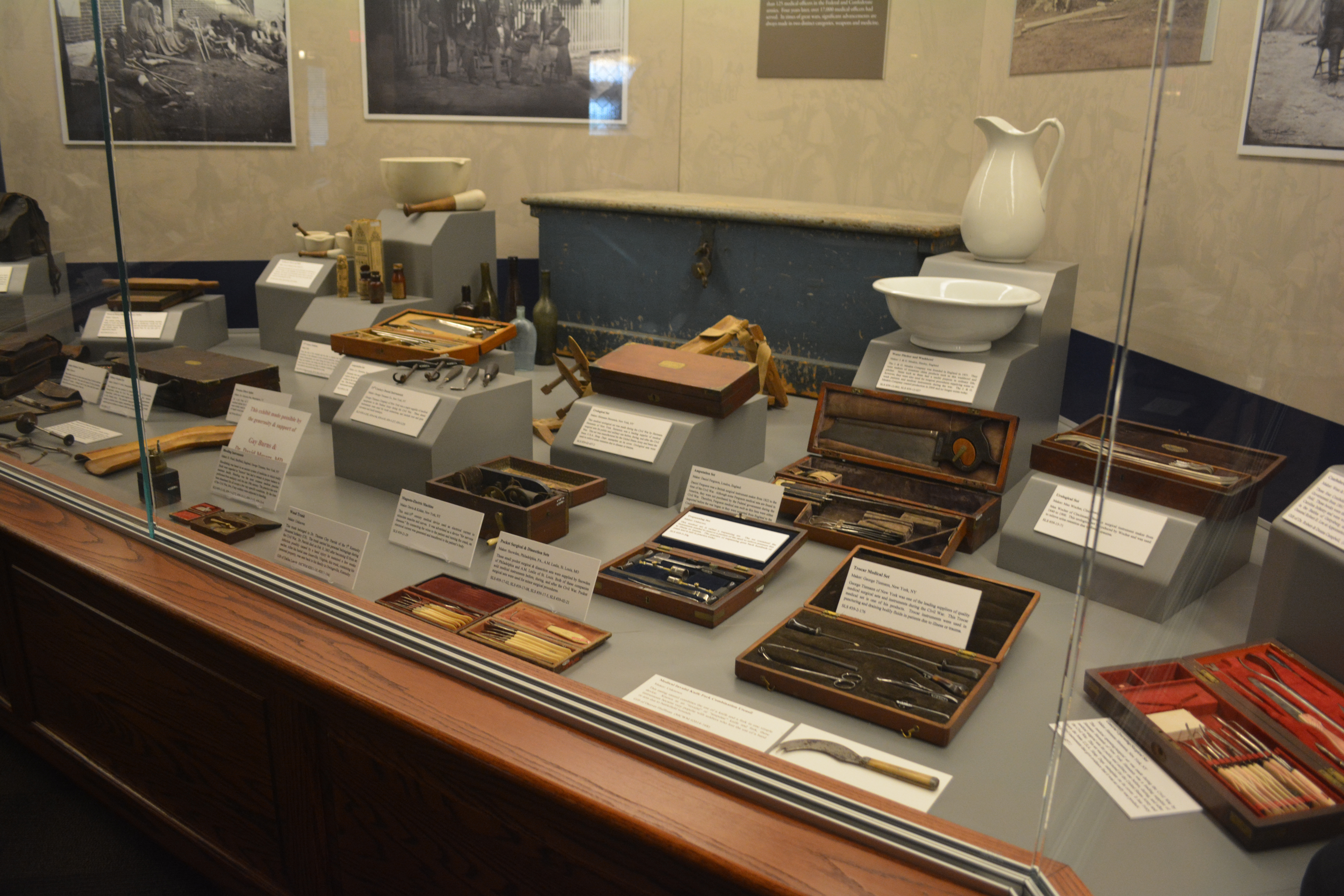 Medical exhibit case containing several amputation sets, vials, and stethoscopes. Image courtesy of Studio 2108.