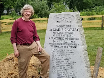 Steve Bunker stands beside 1st ME Cav monument